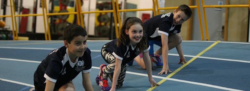 Children crouching at the starting line of a sprint race
