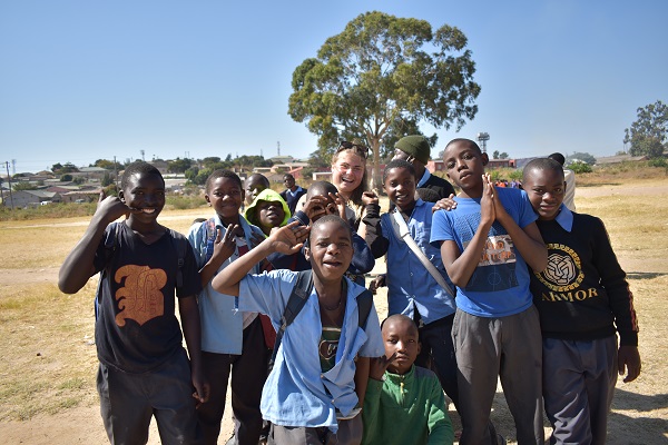 A group of Zambia children and volunteers posing for a photograph