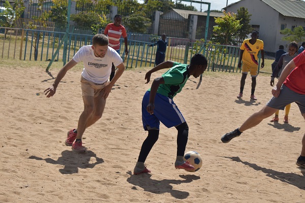 Children and young adults playing football