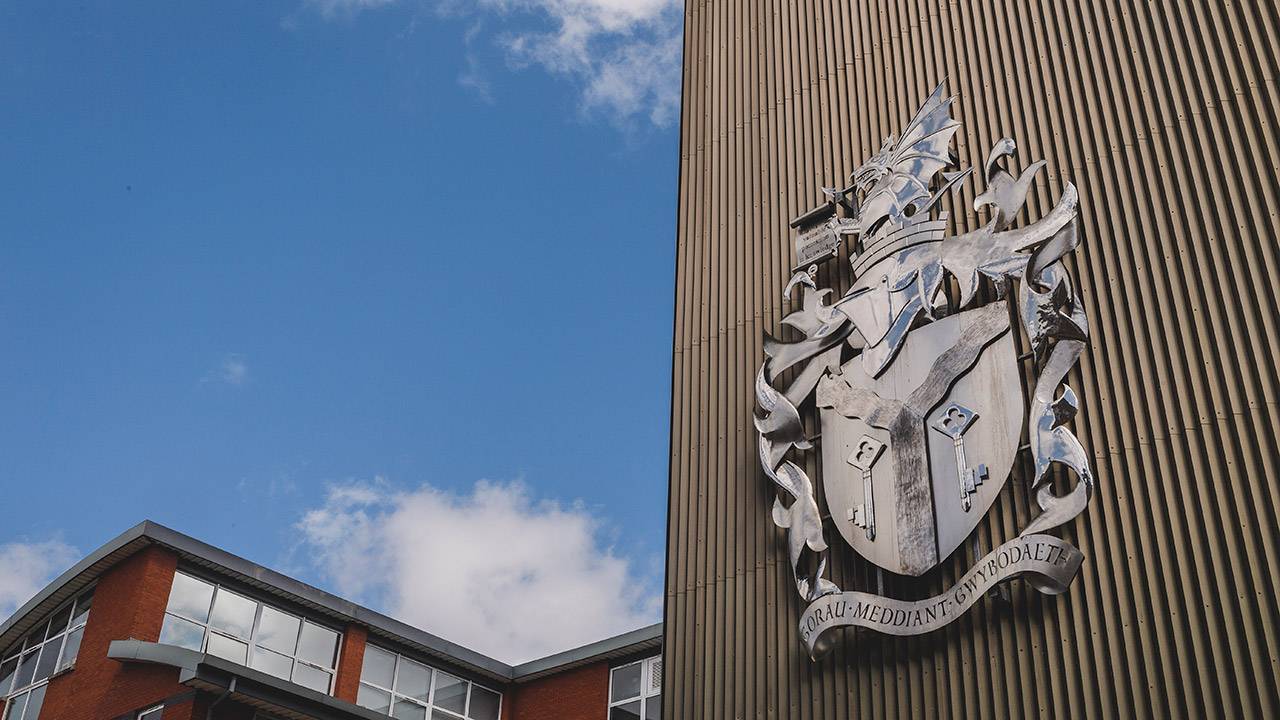 Close-up of Cardiff Met crest on building