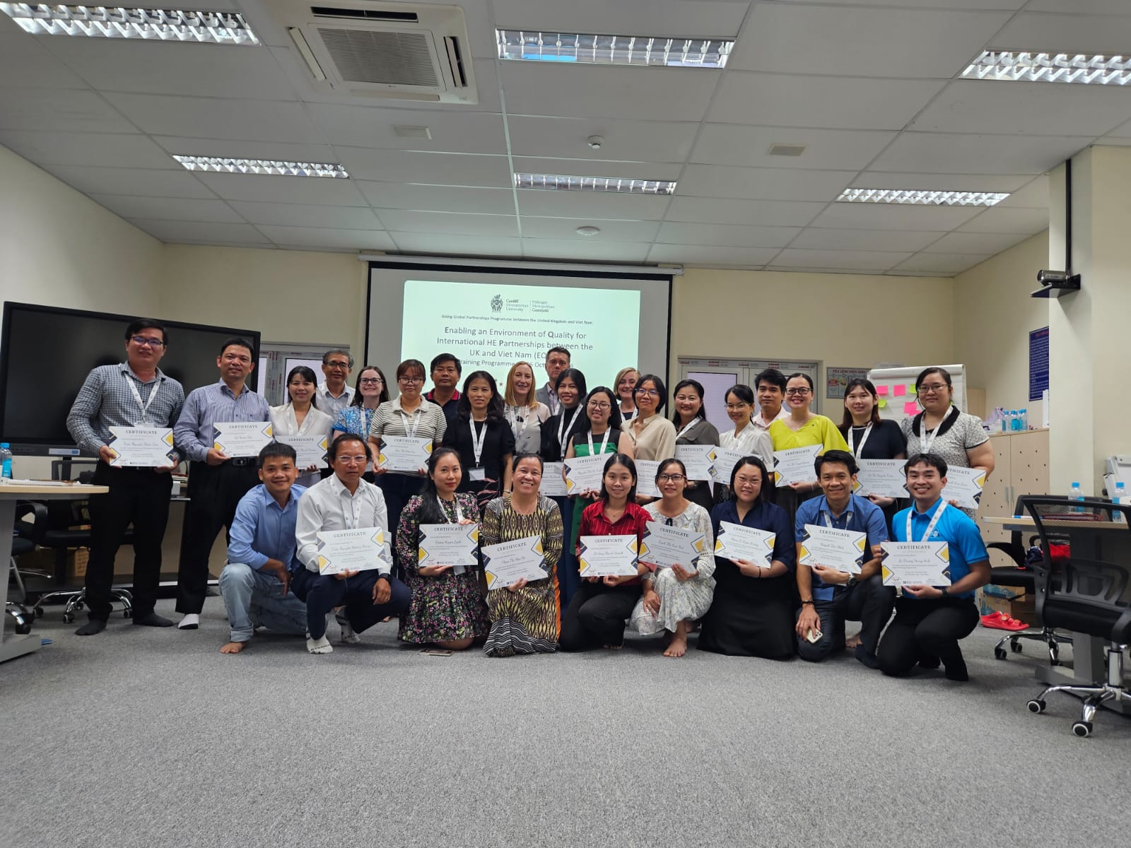 Training staff and class taking a group photograph with their training certificates
