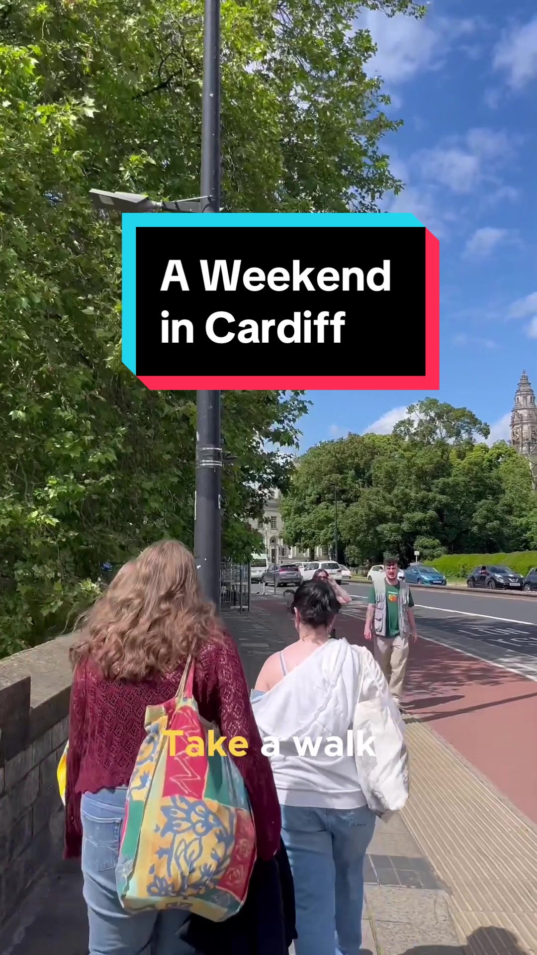 Two young woman walk down the pavement on a sunny day