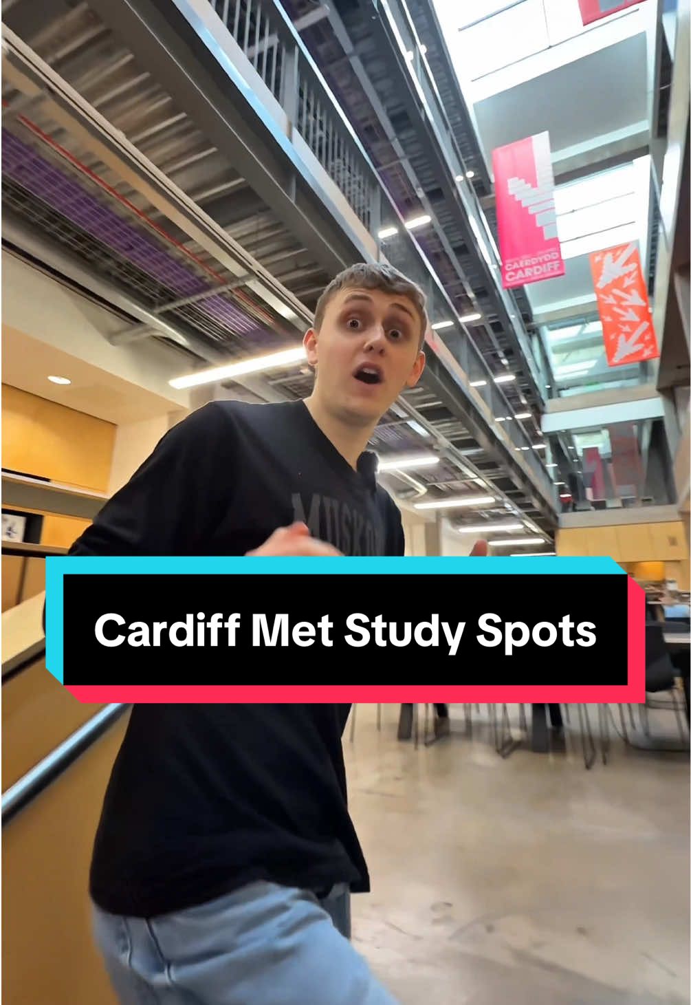 A young man walking through an open space looks to camera while discussing the study spots on Cardiff Metropolitan University campuses