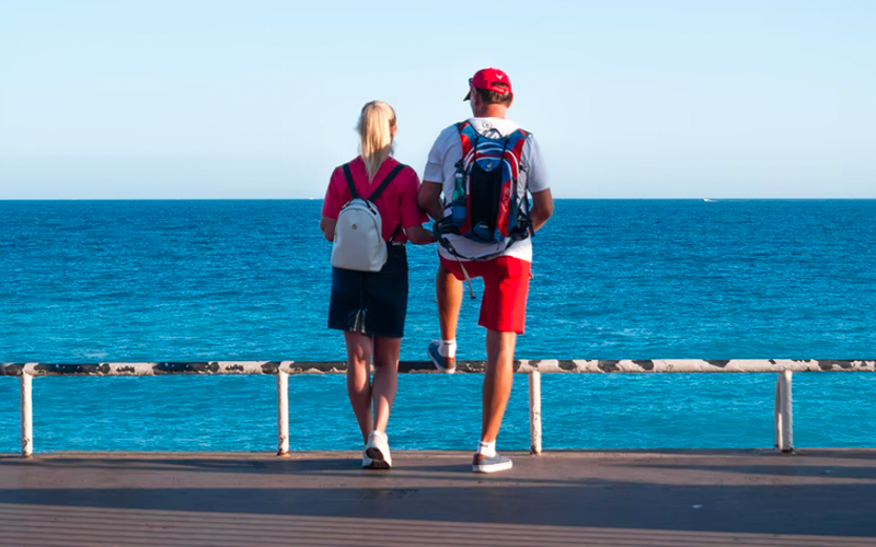 Two people standing on the promenade overlooking the sea